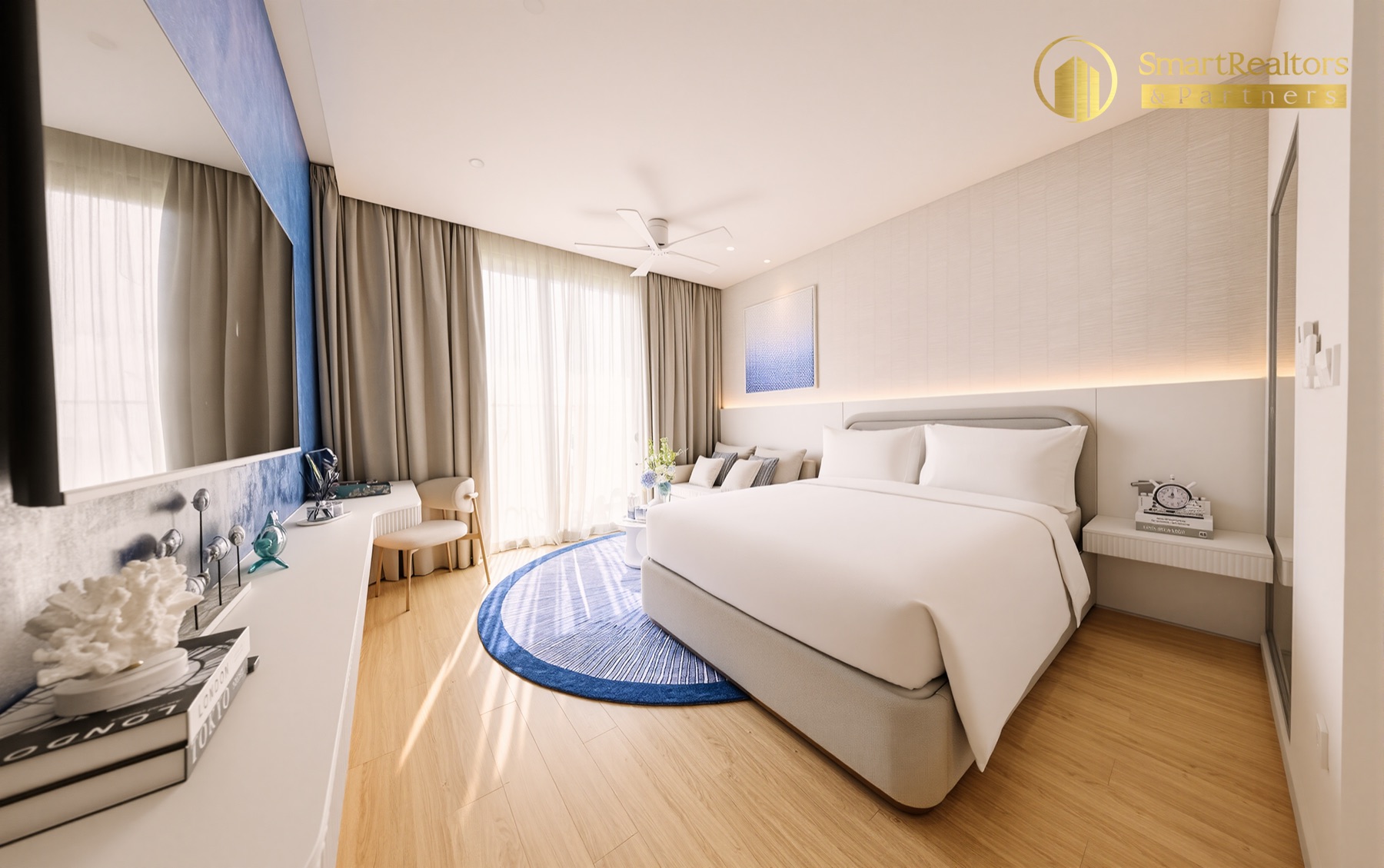 Toàn cảnh căn hộ mẫu Studio với giường đôi, thảm tròn xanh và quầy bàn trang điểm
